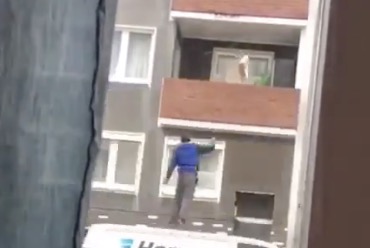 Un livreur lance un colis dans un balcon