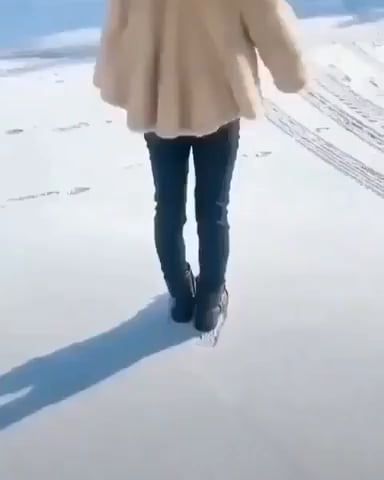 Une fille dessine un cercle parfait sur la neige