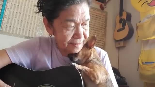 Une vieille dame chante pour son chihuahua