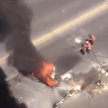 Des pompiers ont beaucoup de mal à éteindre une voiture en feu