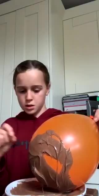 Un enfant fait un bol en chocolat avec un ballon