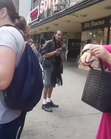 Un homme met un pigeon dans une poubelle