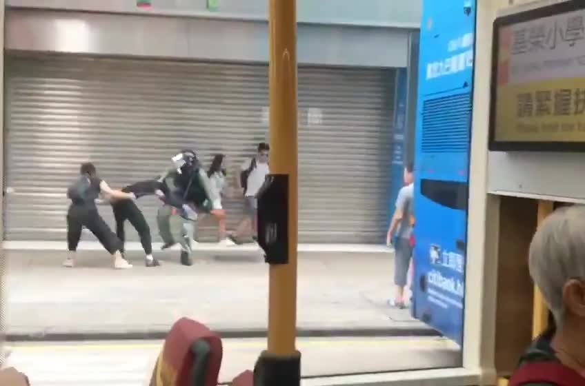 Un manifestant met un high-kick à un policier (Hong Kong)