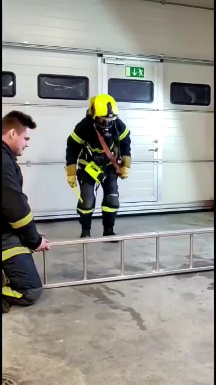 Un pompier doit passer à travers échelle avec tout son équipement