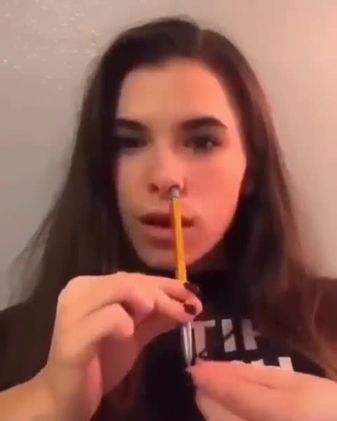 Une fille rentre un crayon entier dans son nez