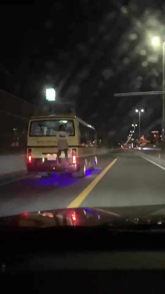 Une femme s'accroche à l'arrière d'un bus sur l'autoroute (Japon)