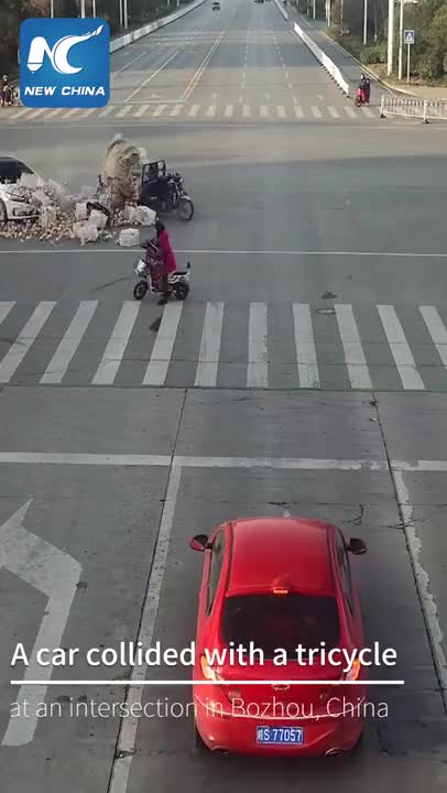 Des passants aident un vendeur de pommes à recharger sa cargaison (Chine)