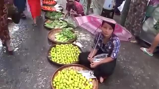 Des voitures passent au milieu d'un marché