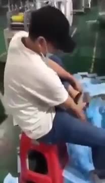 Un ouvrier chinois essuie ses chaussures avec des masques qu’il vient de fabriquer