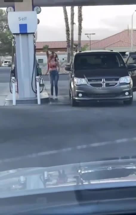 Une fille a beaucoup de mal Ă se garer dans une station essence