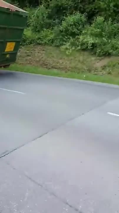 Un camion-benne passe sous un pont très bas