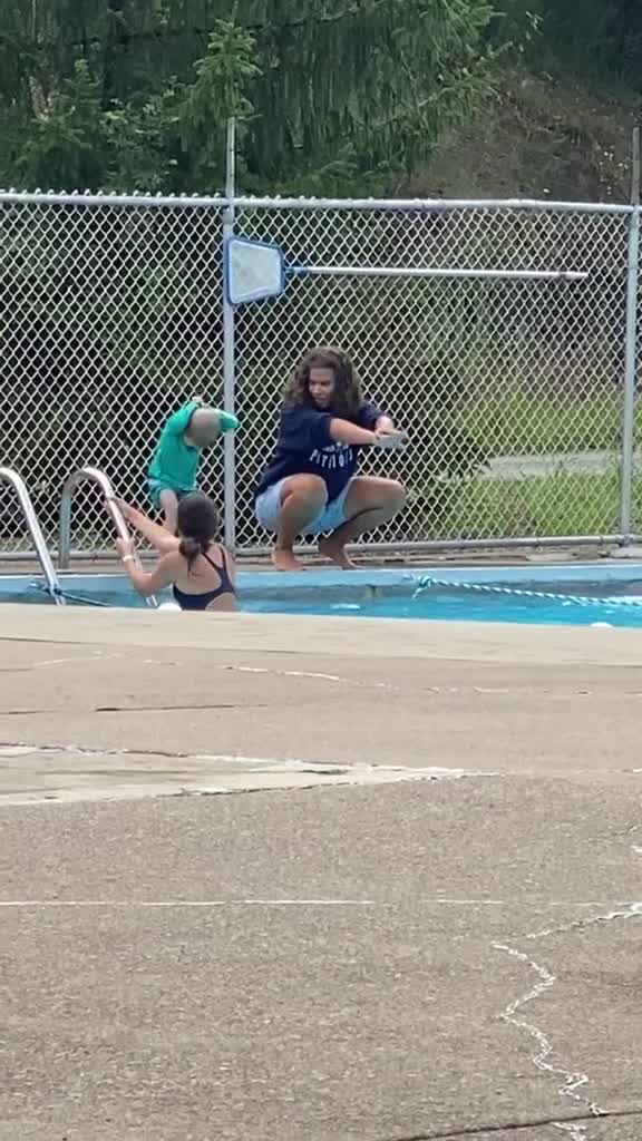 Un petit garçon fait une blague à  son moniteur de natation