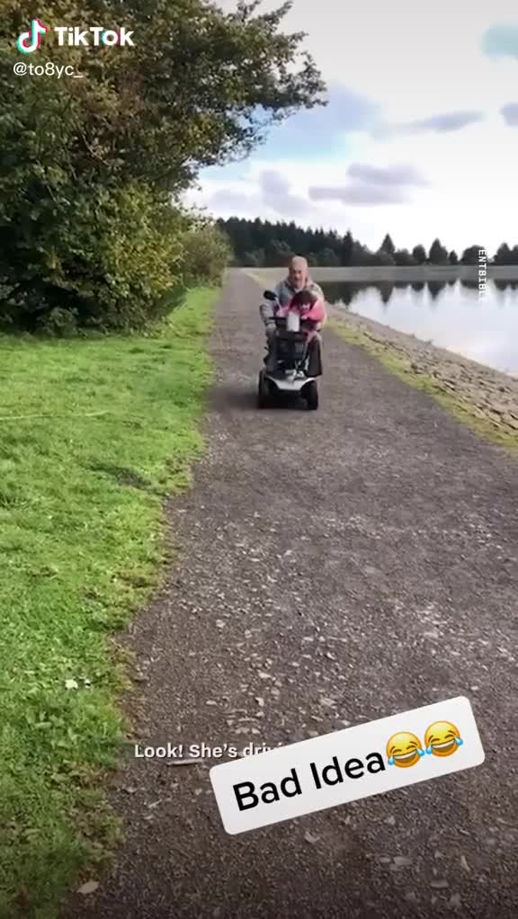 Un grand-père laisse sa petite-fille conduire son mobility scooter