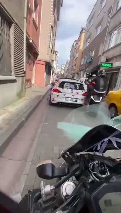 Régis fait une roue arrière dans une petite rue étroite