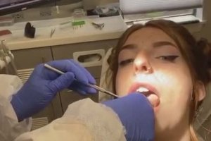 Une fille s'amuse chez le dentiste