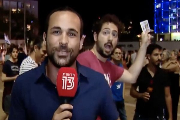 Un homme fait des tours de magie derrière un journaliste (Tel-Aviv)