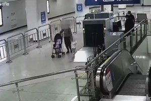 Un agent de sécurité sauve un enfant en haut d'un escalier mécanique