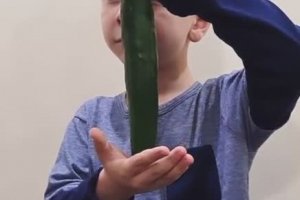 Un enfant fait un tour de magie avec un concombre