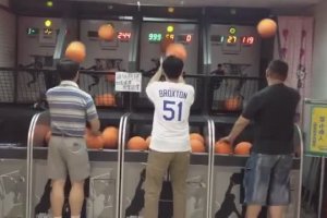Un père de famille passe le temps en jouant au basket d'arcade