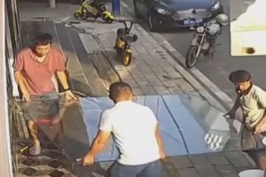 Une femme aide des hommes Ă installer une vitre