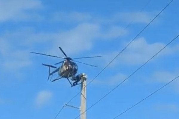 Un électricien fixe une panne avec l'aide d'un hélicoptère