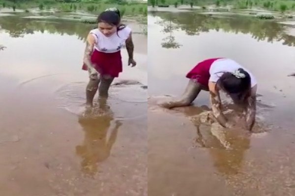 Une fille cherche quelque chose dans la boue