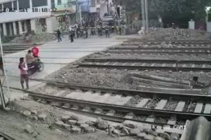 Un motard a très chaud à un passage à niveau (Inde)