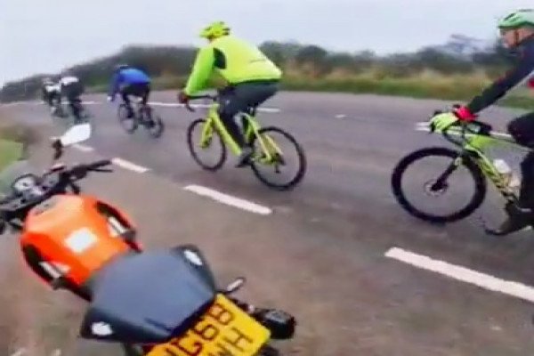 Un motard se fait doubler par des cyclistes