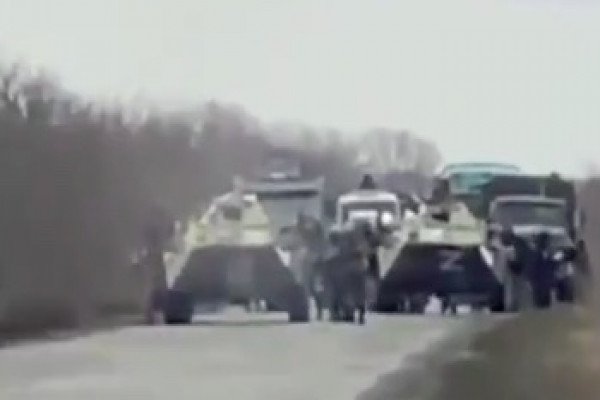 Des civils ukrainiens manifestent devant une colonne de chars russes