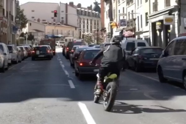 Un homme en motocross roule sur des voitures (France)