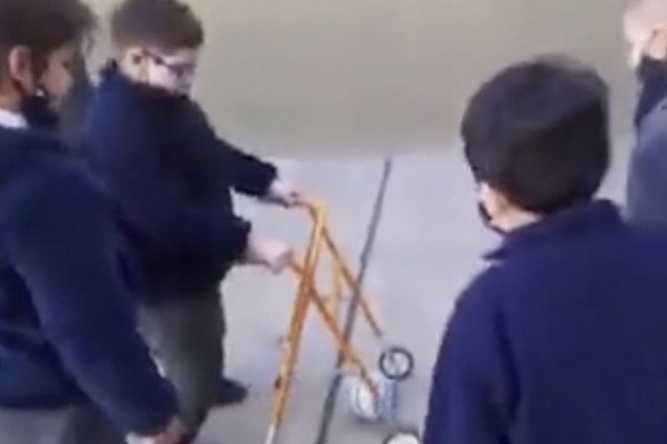 Des petits garçons encouragent leur pote handicapé