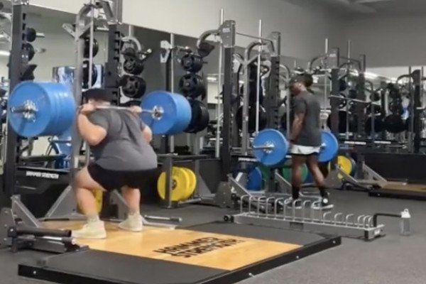 Un homme célèbre sa série de squats dans une salle de sport