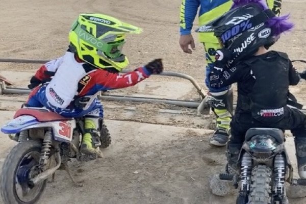 Deux enfants font un check au départ d'une course de motocross