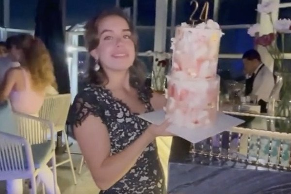 Une fille pose avec son gateau d'anniversaire