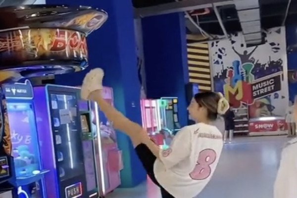 Une fille montre sa souplesse sur une machine punching ball