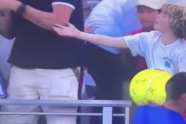 Un joueur de tennis offre sa casquette Ă un enfant, un adulte la vole