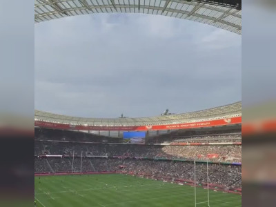Un avion survole un stade bondé